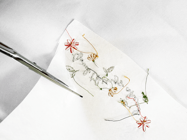 Cut-away backing stabilizer used for machine embroidery on a floral design.